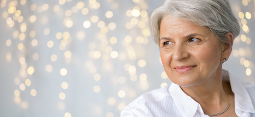 Image showing portrait of senior woman over festive lights