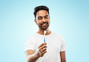 Image showing indian man with toothbrush over blue background