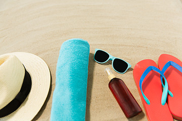 Image showing straw hat, flip flops and sunglasses on beach sand