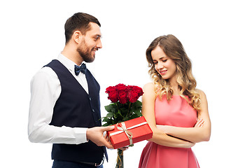 Image showing happy man giving woman flowers and present