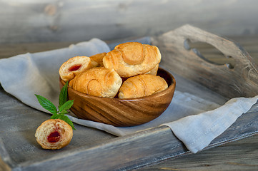 Image showing Croissants on a wooden tray. The concept of a wholesome breakfast.