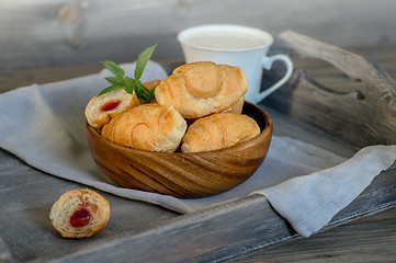 Image showing Croissants on a wooden tray. The concept of a wholesome breakfast.