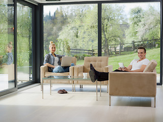 Image showing couple relaxing at  home with tablet and laptop computers