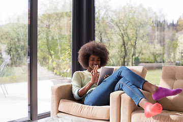 Image showing young african american woman at home using digital tablet