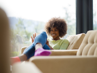 Image showing young african american woman at home using digital tablet