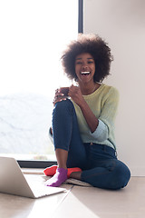 Image showing black woman in the living room on the floor