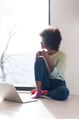 Image showing black woman in the living room on the floor