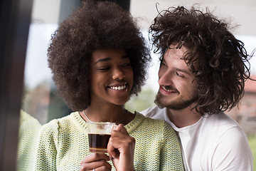 Image showing happy multiethnic couple relaxing at modern home indoors