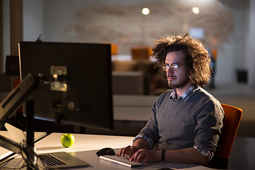 Image showing man working on computer in dark office