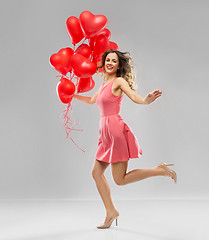 Image showing happy young woman with red heart shaped balloons