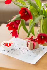 Image showing gift box, calendar sheet and flowers on table