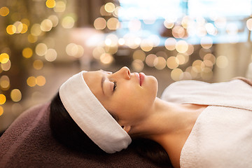 Image showing young woman with headband lying in spa parlor