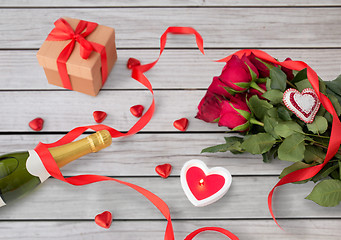 Image showing close up of champagne, gift, candies and red roses