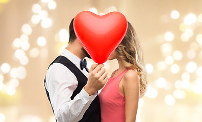 Image showing couple hiding behind red heart shaped balloon