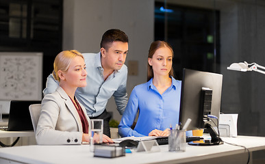 Image showing business team with computer working late at office