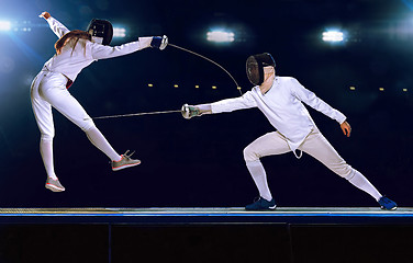 Image showing Two fencing athletes fight on professional sports arena