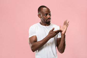 Image showing Beautiful male half-length portrait isolated on pink studio backgroud. The young emotional surprised man