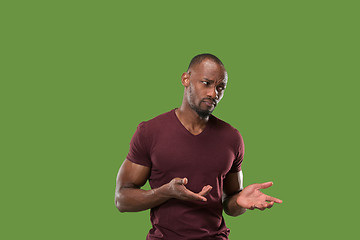 Image showing Beautiful male half-length portrait isolated on green studio backgroud. The young emotional surprised man