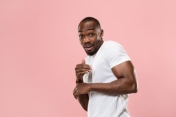 Image showing Beautiful male half-length portrait isolated on pink studio backgroud. The young emotional surprised man