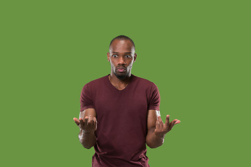 Image showing Beautiful male half-length portrait isolated on green studio backgroud. The young emotional surprised man