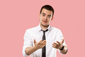 Image showing Beautiful male half-length portrait isolated on pink studio backgroud. The young emotional surprised man