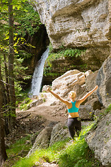 Image showing Active woman raising arms inhaling fresh air, feeling relaxed in nature.