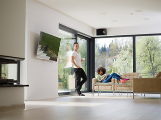 Image showing multiethnic couple relaxing at  home with tablet computers