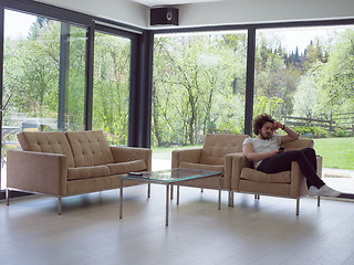 Image showing young man using a mobile phone  at home