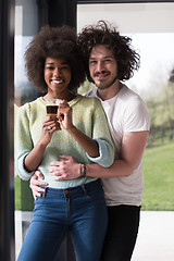 Image showing happy multiethnic couple relaxing at modern home indoors