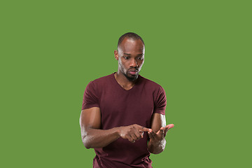 Image showing Beautiful male half-length portrait isolated on green studio backgroud. The young emotional surprised man