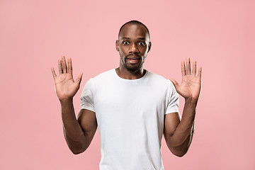 Image showing Beautiful male half-length portrait isolated on pink studio backgroud. The young emotional surprised man