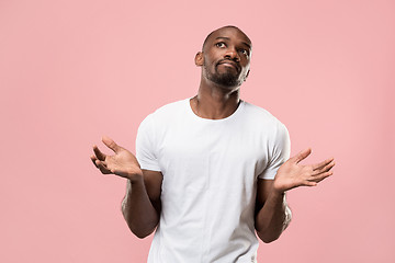 Image showing Beautiful male half-length portrait isolated on pink studio backgroud. The young emotional surprised man