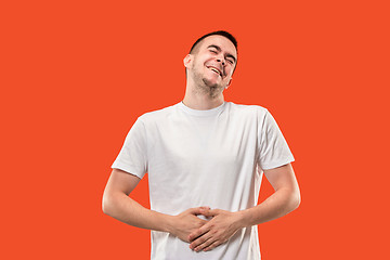 Image showing The happy businessman standing and smiling against orange background.