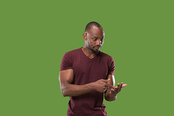 Image showing Beautiful male half-length portrait isolated on green studio backgroud. The young emotional surprised man