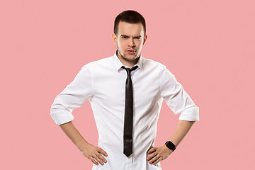 Image showing The serious businessman standing and looking at camera against pink background.