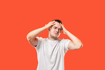 Image showing Man having headache. Isolated over red background.