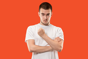 Image showing The young emotional angry man screaming on orange studio background