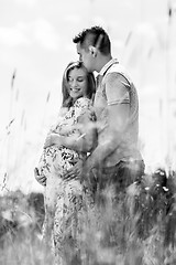 Image showing Young happy pregnant couple hugging in nature.