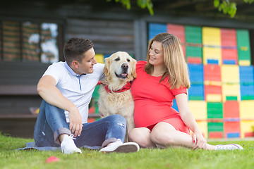 Image showing A Young couple expecting baby with their Golden retriever dog