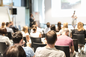 Image showing Businessman in audience standing and asking question to speeker at business conference.