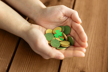 Image showing hands with golden coins and shamrock leaf