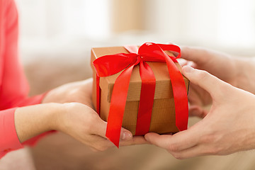 Image showing close up of male and female hands with gift box