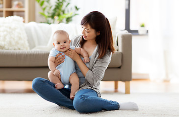 Image showing happy young mother with little baby at home