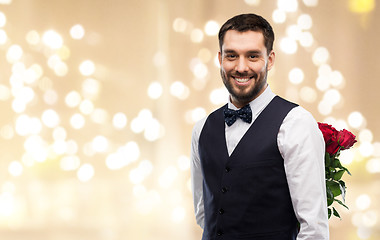 Image showing happy man with red roses behind his back