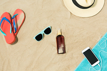 Image showing smartphone, hat, flip flops and shades on beach