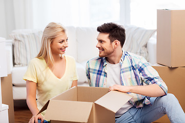 Image showing happy couple unpacking boxes at new home