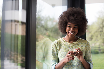 Image showing African American woman drinking coffee looking out the window