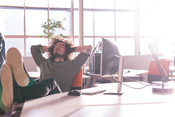 Image showing businessman sitting with legs on desk