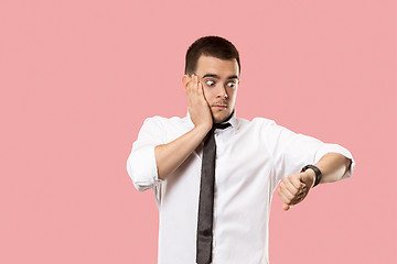 Image showing Handsome businessman checking his wrist-watch Isolated on pink background