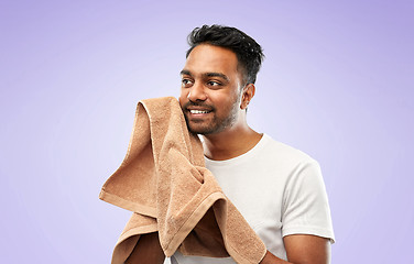 Image showing indian man using bath towel over violet background